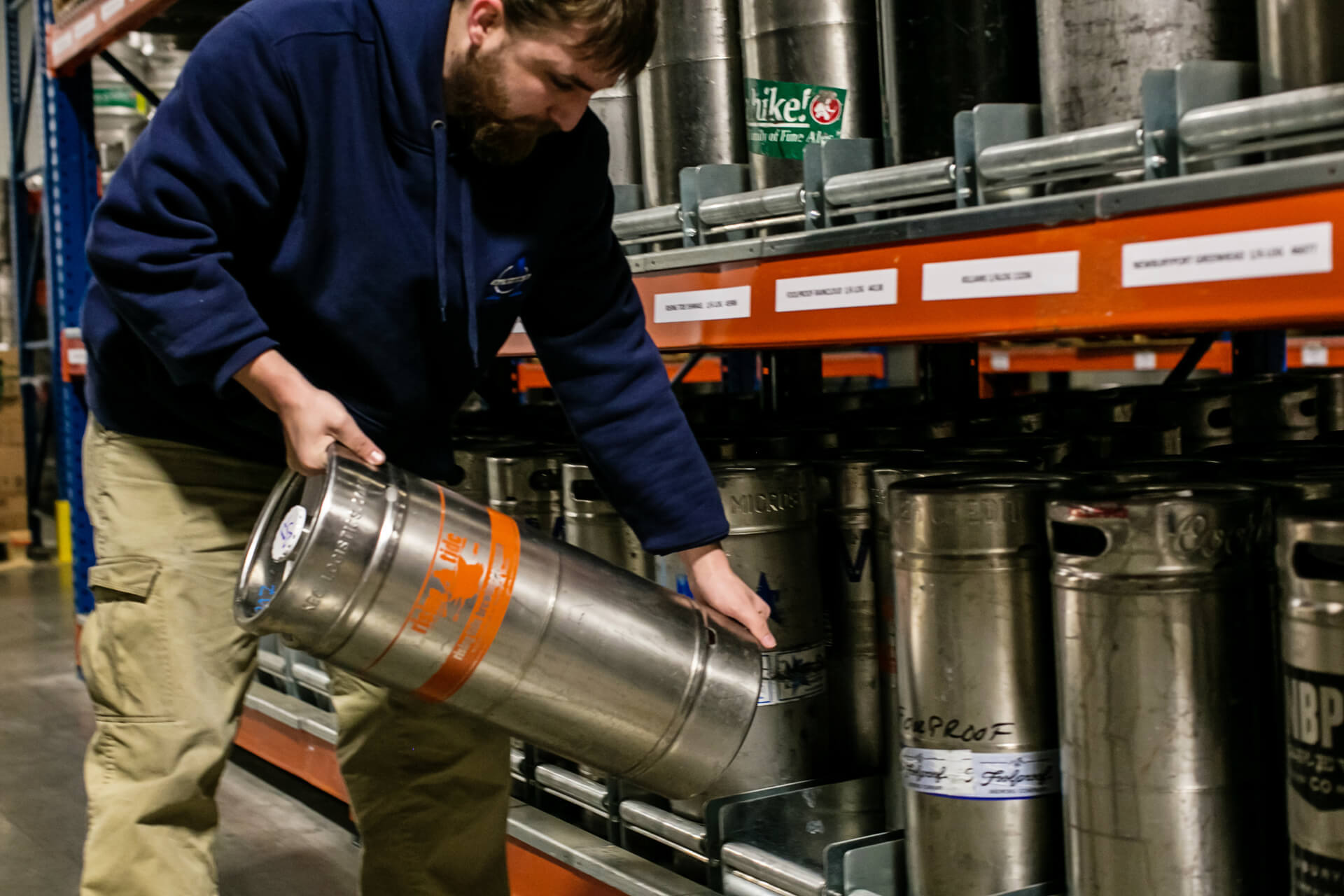 Worker safely picking a keg from keg storage solution